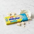 Nestlé Milkybar white chocolate bar with milk splash on white marble - professional product photo